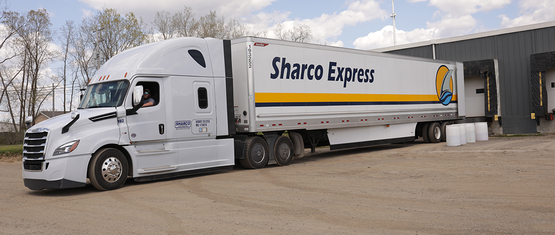 Large truck parked in front of a building. Full Truckload Transportation Services in Michigan.